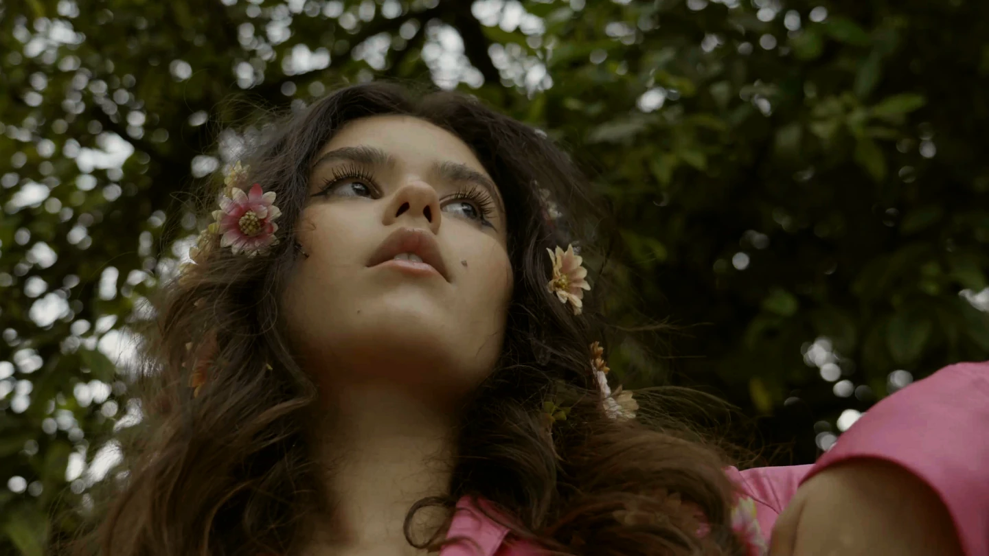 Fotograma real de una mujer con flores en el pelo, filmado por Rafael Nicida.